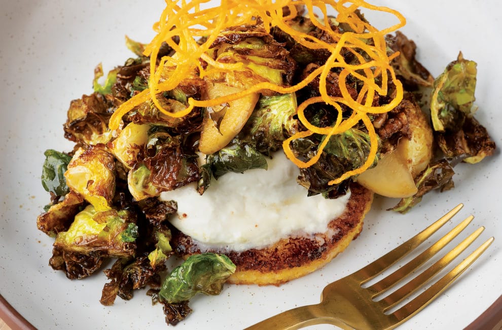 brussel sprouts on burrata cheese atop a crispy polenta cake