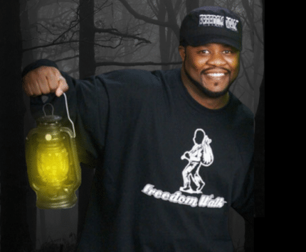 A man holding a lantern in the woods