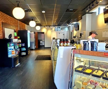 interior of a deli with glass cases and employee