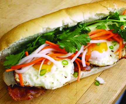 A long baguette filled with egg, cilantro, and carrot