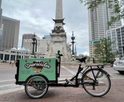 a green ice cream bicycle parked in from of the Soldiers & Sailors monument