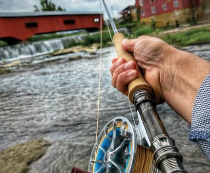a hand on a fly fishing pole