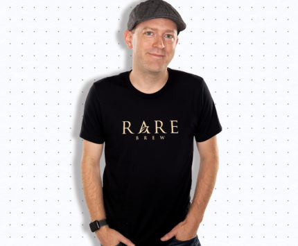 A man wearing a hat and a black t-shirt