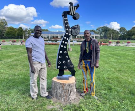 Two men standing next to a statue in Garfield Park