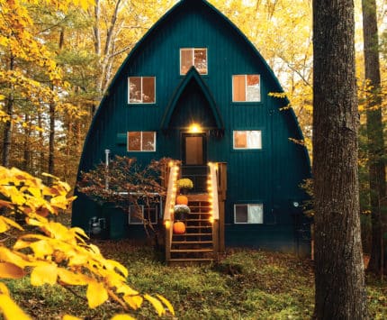 A blue arched cabin in the middle of rich yellow trees