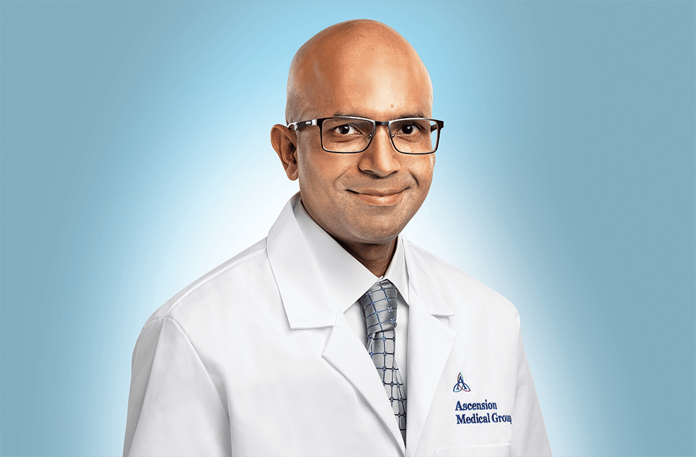 a bald man wearing glasses in a doctor's coat