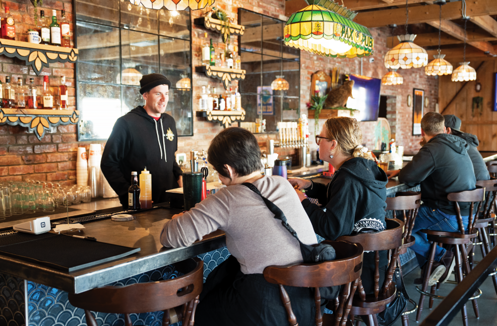 The bartender chats with patrons at the bar of Natural State