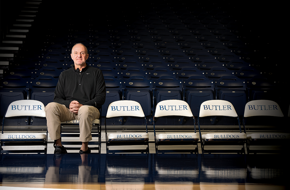 Butler basketball head coach Thad Matta sitting alone on side court Butler branded seating